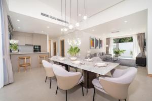 Ban Phru ChampaにあるCoco Villas Phuket - 3 Bedroom Deluxe Garden Pool Villa by Escape Villasのダイニングルーム、キッチン(テーブル、椅子付)