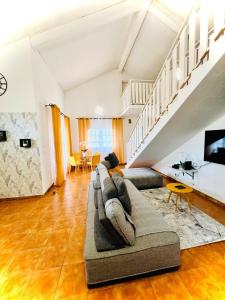 La Villa Des Lys avec jacuzzi في سان دوني: غرفة معيشة مع أريكة وتلفزيون