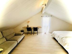 La Villa Des Lys avec jacuzzi في سان دوني: غرفة نوم في العلية مع أريكة وطاولة +80 صورة