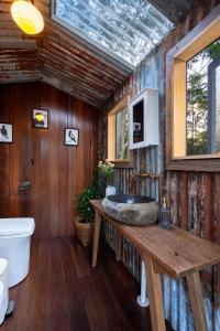 a bathroom with a stone sink and a window at The Hollows - Kangaroo Valley in Kangaroo Valley