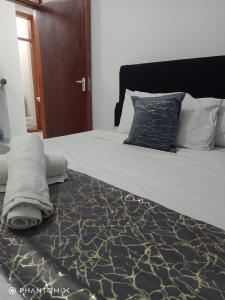 a bedroom with a large white bed with a blue pillow at Fastcare Buxton 3 bedroom Apartment in Mombasa