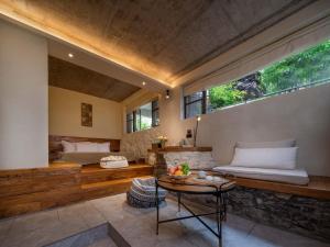 een woonkamer met een bed en een tafel bij 兴义市田景宜色客栈 in Nahui