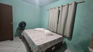 a small bedroom with a bed and a window at Casa de Granja-Praia de Cotovelo in Parnamirim