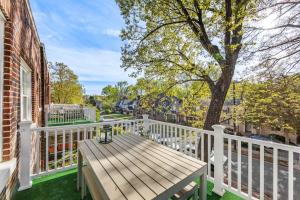 a porch with a wooden bench on a white fence at Vibrant and Cozy 2BR near Uptown with Balcony in Charlotte
