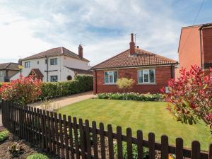 ein Haus mit einem Zaun vor einem Hof in der Unterkunft Field Cottage in York