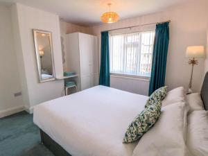 ein Schlafzimmer mit einem großen weißen Bett und einem Fenster in der Unterkunft Field Cottage in York