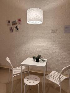 a table and chairs with a white table and a light at Electrifying 2 BHK Getaway in Bengaluru