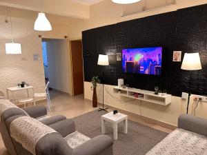 a living room with a couch and a flat screen tv at Electrifying 2 BHK Getaway in Bengaluru