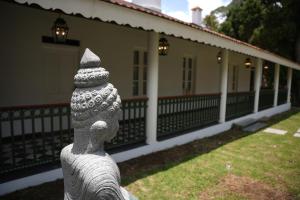 a stone statue in front of a house at The Tredis Heritage by the Lake in Kodaikānāl