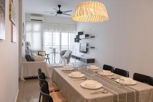 une salle à manger avec une table et quelques chaises dans l'établissement The White House - 3BR Meridin Bayvue, à Masai