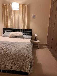 a bedroom with a bed and a lamp on a table at Electrifying 2 BHK Getaway in Bengaluru +11 photos