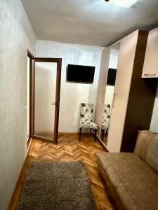 Zimmer mit Sofa, Stuhl und TV in der Unterkunft Zen Apartment in Galaţi + 1 Foto