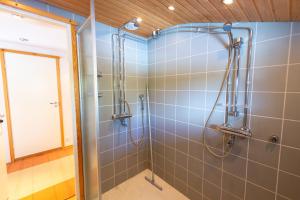 a shower with a glass door in a bathroom at Vaeltajanmaja in Saariselka