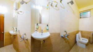 a bathroom with a sink and a toilet at Treebo Royal Empire Indore in Indore +21 photos