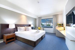 Rúm í herbergi á King Studio Harbourfront Haven with Tropical Pool