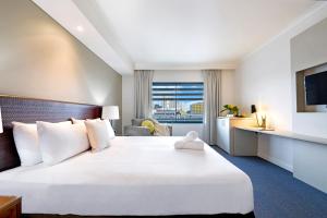 Rúm í herbergi á King Studio Harbourfront Haven with Tropical Pool