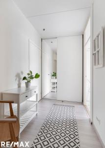 a white hallway with a desk and a table at Viherkallio two room apartment with kitchen and balkony in Espoo