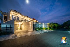 a large house with a driveway at night at Villa Blissful - by Unicorn Villas Bali in Nusa Dua