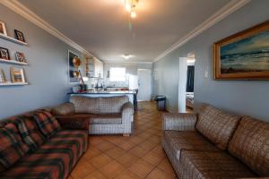 a living room with a couch and a kitchen at Lemnos 14 in Margate