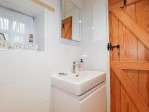 a bathroom with a sink and a toilet and a mirror at 2 Rose Cottage in St. Agnes  +19 photos