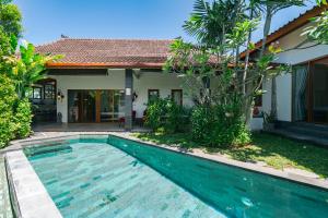 a swimming pool in front of a house at Villa Moringa 2 - Private Villa in the Heart of Canggu, 5 Minutes from the Beach in Canggu