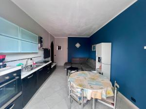 a kitchen with a table and a blue wall at Casa Irene in Nichelino
