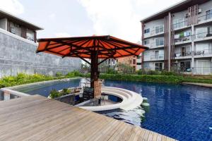 a pool with an umbrella next to a building at Rockstarvillas Condos Replay in Bophut