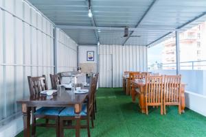 a dining room with wooden tables and chairs at Treebo Emirates Suites Indiranagar in Bengaluru