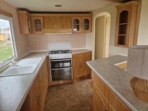 a kitchen with wooden cabinets and a stove top oven at I love Costinesti in Costinesti
