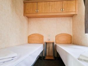 two beds in a room with wooden cabinets at I love Costinesti in Costinesti