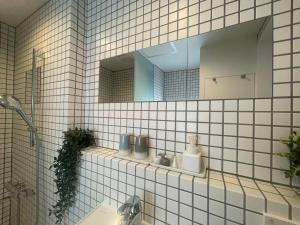 Baño de azulejos blancos con espejo y lavabo en GalleryInn Fuji, Shibuya, en Tokio 44 fotos más