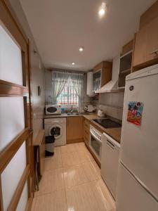 Una cocina con un refrigerador blanco y un fregadero. en Oropesa del Mar, en El Borseral