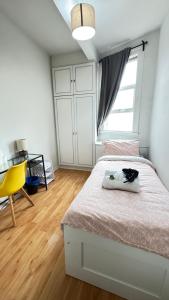 una camera da letto con un letto e una sedia gialla di Single room near Bayswater close to tube & Bus a Londra