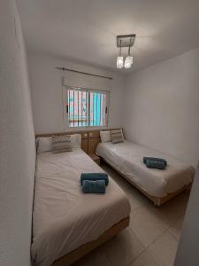 Un dormitorio con dos camas y una ventana. en Oropesa del Mar, en El Borseral 9 fotos más