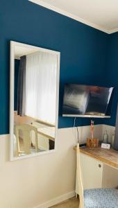 a mirror on a wall in a room with a table at Stefans Gästezimmer in Kirchhatten