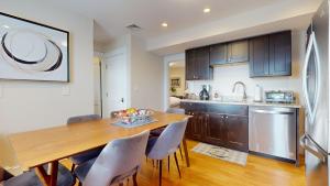a kitchen and dining room with a wooden table and chairs at Spacious 5br W Ac, Near Harvard & Davis Sq in Cambridge