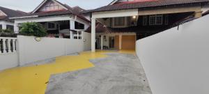 an empty courtyard of a house with a white fence at 7 minutes driving to TC Beach 123 Guest House in Kuantan