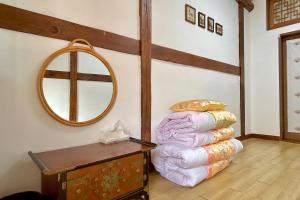 a room with a pile of pillows and a mirror at Private hanok with 4 bedrooms Hanok Stay Sara in Jeonju