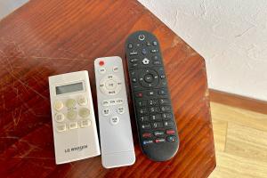 two remote controls sitting on top of a table at Private hanok with 4 bedrooms Hanok Stay Sara in Jeonju +38 photos