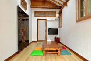 a living room with a table and a tv at Private hanok with 4 bedrooms Hanok Stay Sara in Jeonju