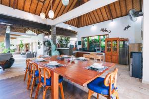 a dining room with a large wooden table and chairs at Villa Moringa 1 - 3 Bedrooms Villa in Canggu Central in Canggu