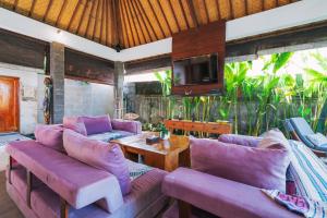 a living room with purple couches and a tv at Villa Moringa 1 - 3 Bedrooms Villa in Canggu Central in Canggu