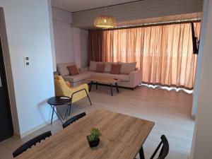 a living room with a table and a couch at Perla Beach in Agia Marina Nea Kydonias