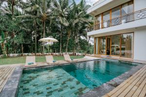 Garden of Harmony Ubud - Rice Field View Stay في أوبود: منزل به مسبح و منزل