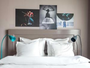 1 dormitorio con 1 cama con almohadas y carteles blancos en Story Hotel Signalfabriken, part of JdV by Hyatt, en Sundbyberg