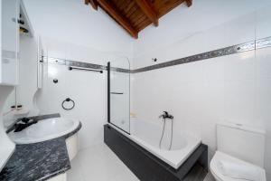 a bathroom with a sink and a tub and a toilet at Elida Inn Near ATH Airport in Markopoulo +90 photos