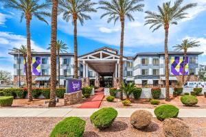 梅萨Spark by Hilton Phoenix East Mesa的一栋建筑前有棕榈树的酒店