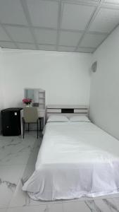a white bedroom with a large bed and a chair at Flower homestay in Thôn Dương Xuân Hạ
