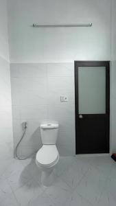 a bathroom with a toilet and a black door at Flower homestay in Thôn Dương Xuân Hạ