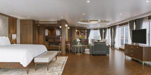 a bedroom with a large bed and a living room at Paradise Legacy Cruise Halong in Ha Long